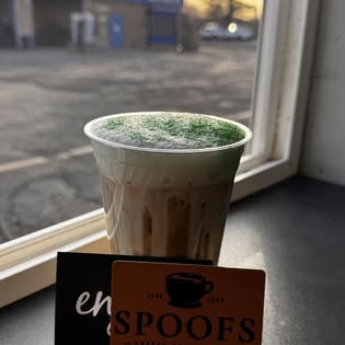 A matcha latte on the windowsill beside a Spoof's gift card